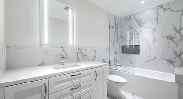 a white bathroom with a toilet and a sink
