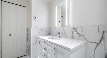 a white bathroom with a sink and a mirror
