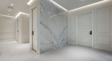a white marble wall in a room with white doors