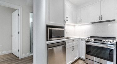 a white kitchen with a stove and a microwave