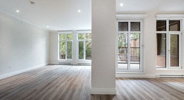 an empty living room with wood floors and windows
