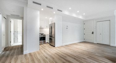 an empty living room with white walls and wooden floors