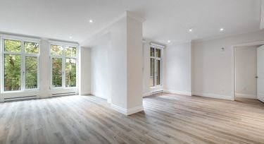an empty living room with white walls and wood floors