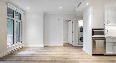 a kitchen with white cabinets and a large window
