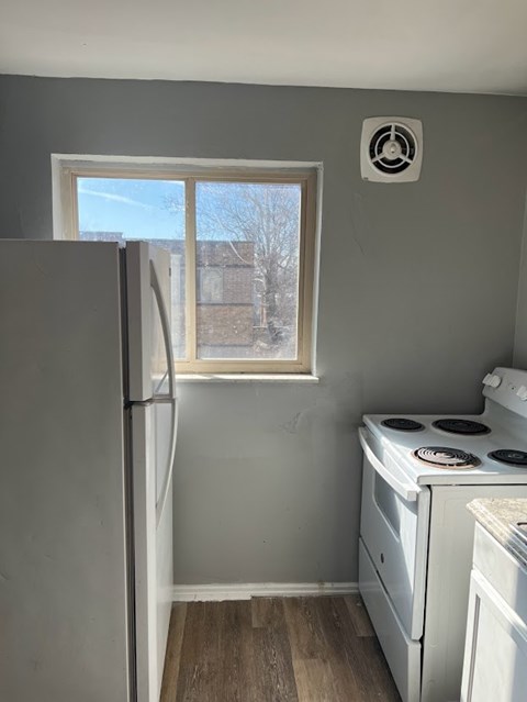 A small kitchen with a white fridge and a white stove.