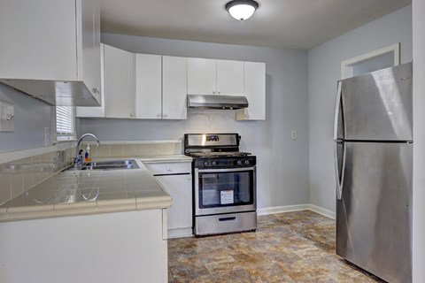 A kitchen with a stove top oven and a refrigerator.
