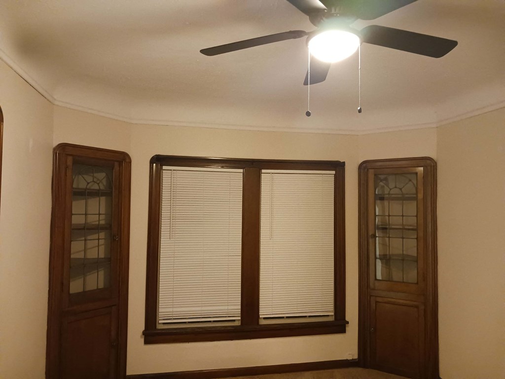 a living room with two windows and a ceiling fan