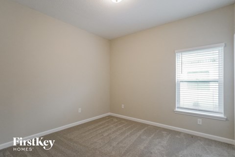 the upstairs bedroom with carpet and window