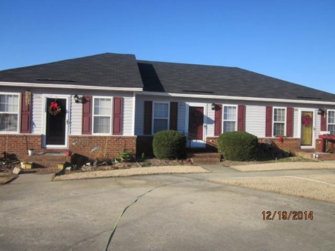 A house with red and white decorations on the front door.