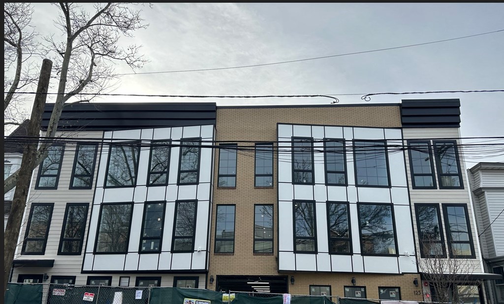 a large building with many windows and a fence in front of it