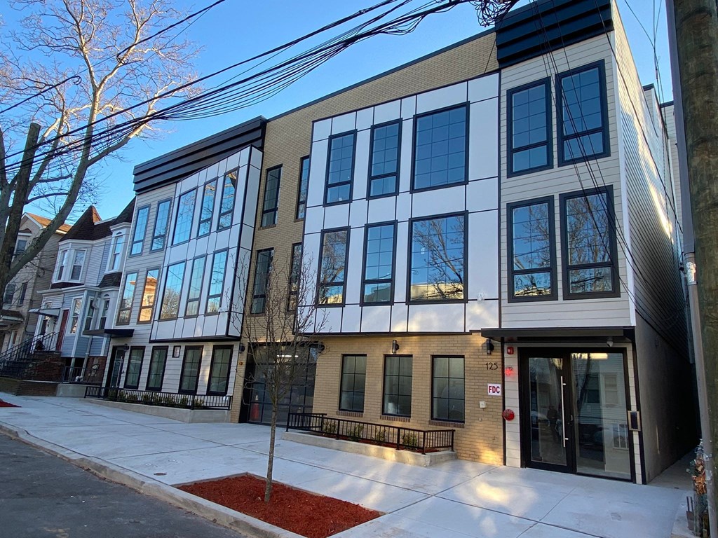 a new building with a sidewalk in front of it