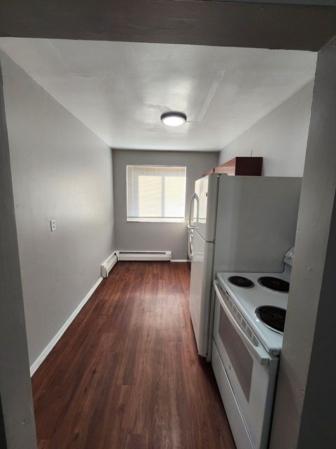 A kitchen with a stove top oven and a window.