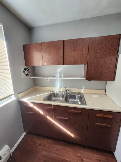 A kitchen with brown cabinets and a white sink.