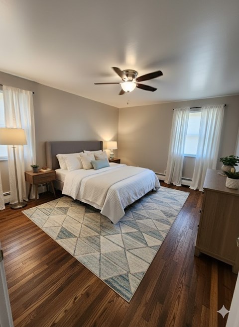 A bedroom with a bed, nightstand, and a ceiling fan.