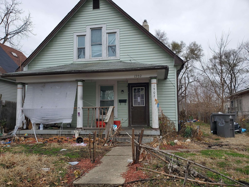 the front porch of a house is covered in plastic and junk