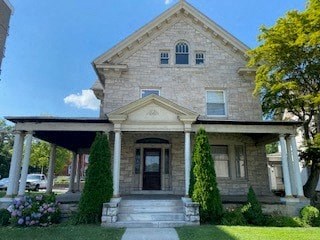 the front of a brick house with a covered porch