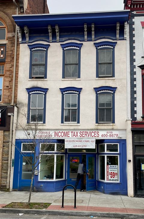 the front of the income tax services office in a white building with blue trim