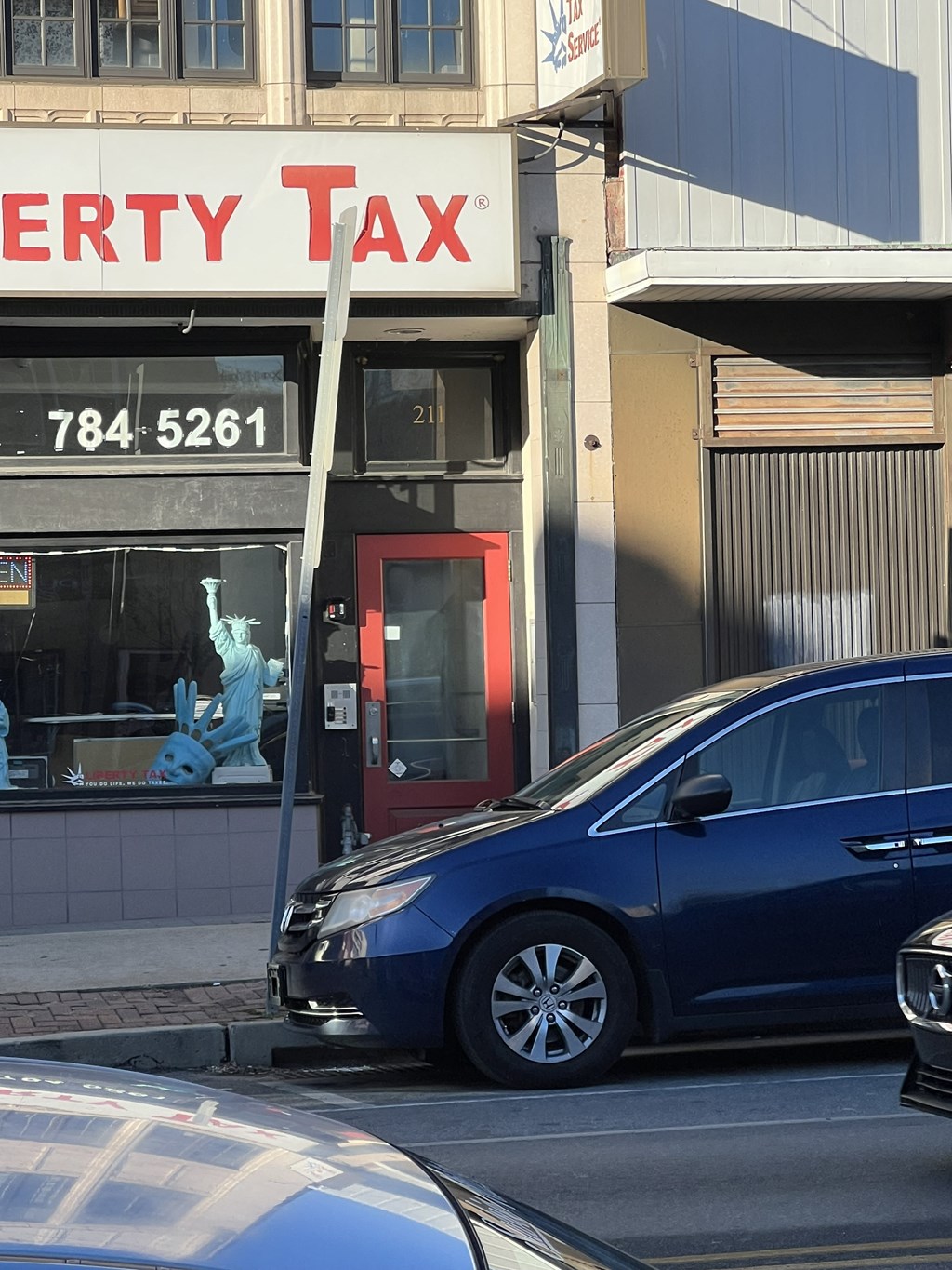 a blue car parked in front of a tax