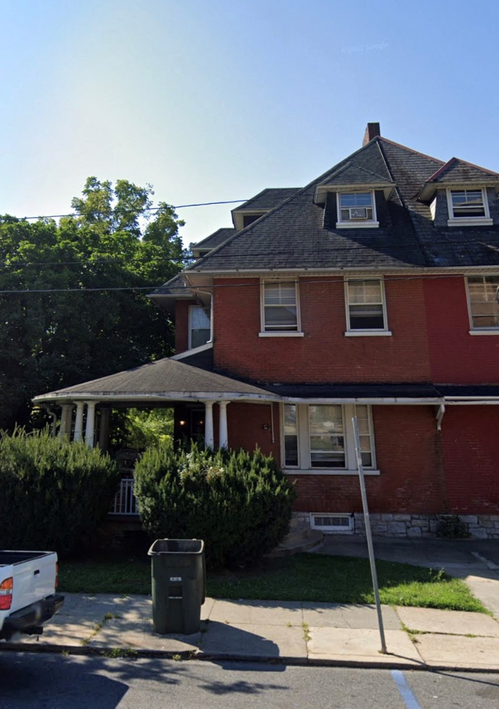 a red house with a trash can in front of it
