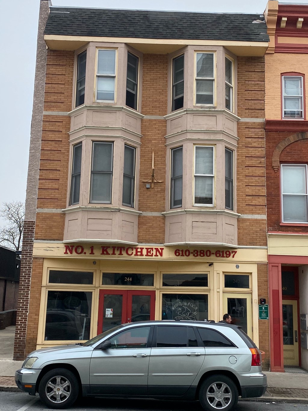a silver car parked in front of a building