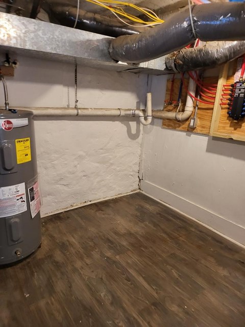 a room with a water heater and pipes on the wall