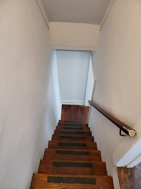 a staircase with wooden steps and a wooden hand rail