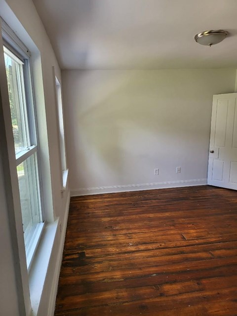 a empty room with wooden floors and a window