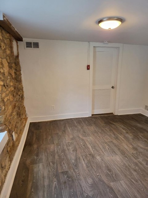 a living room with a wooden floor and a white door