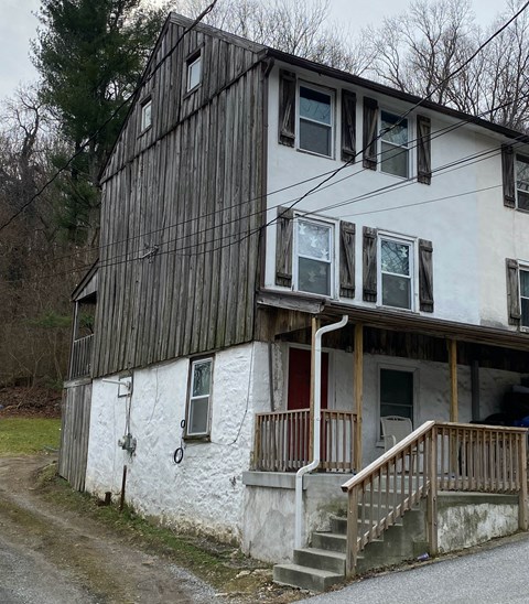 a white house with a porch and a wooden