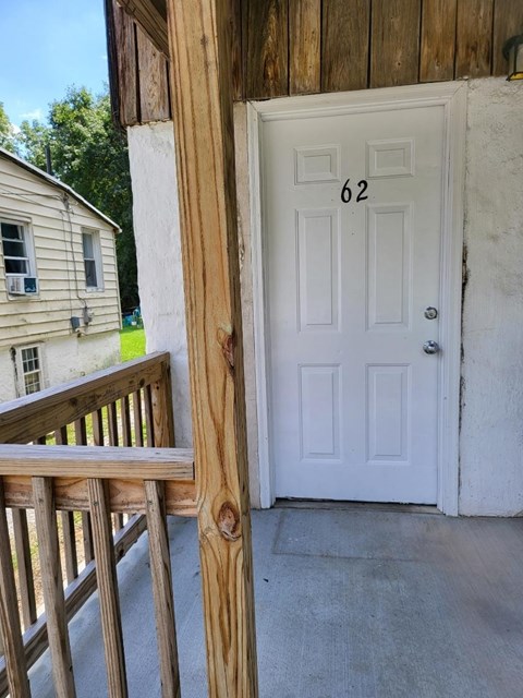 a porch with a white door and a porch swing