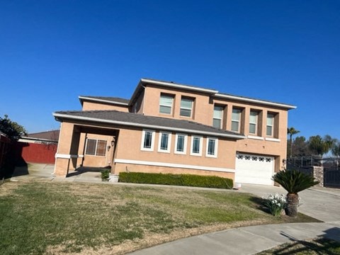 a large brick house with a garage and a lawn