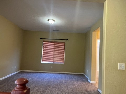 an empty room with a window and a carpeted floor