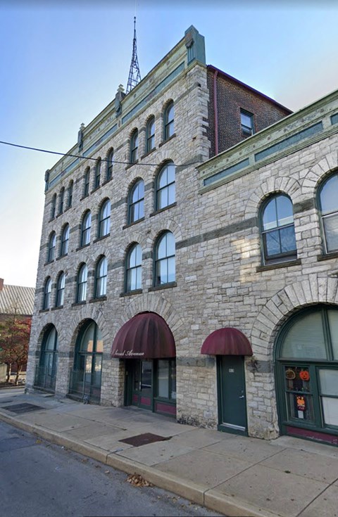 A stone building with a red awning and a sign that says "The".
