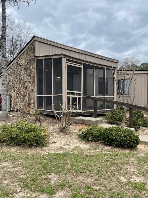 A small house with a brown wooden exterior and a glass door.