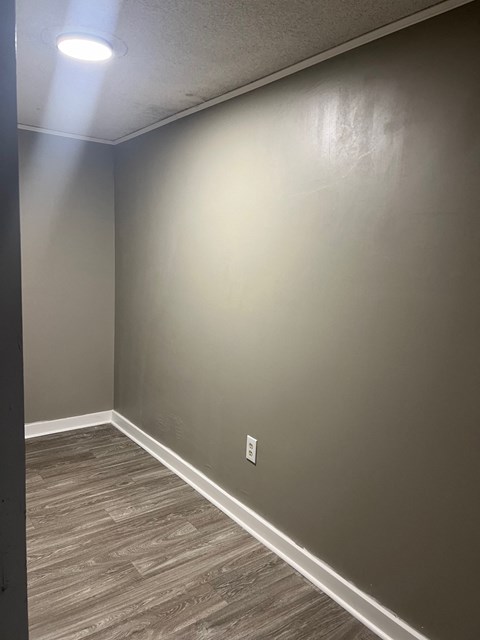 A room with a light on the ceiling and a light switch on the wall.