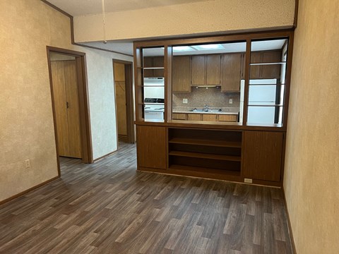 A kitchen area with wooden floors and cabinets.