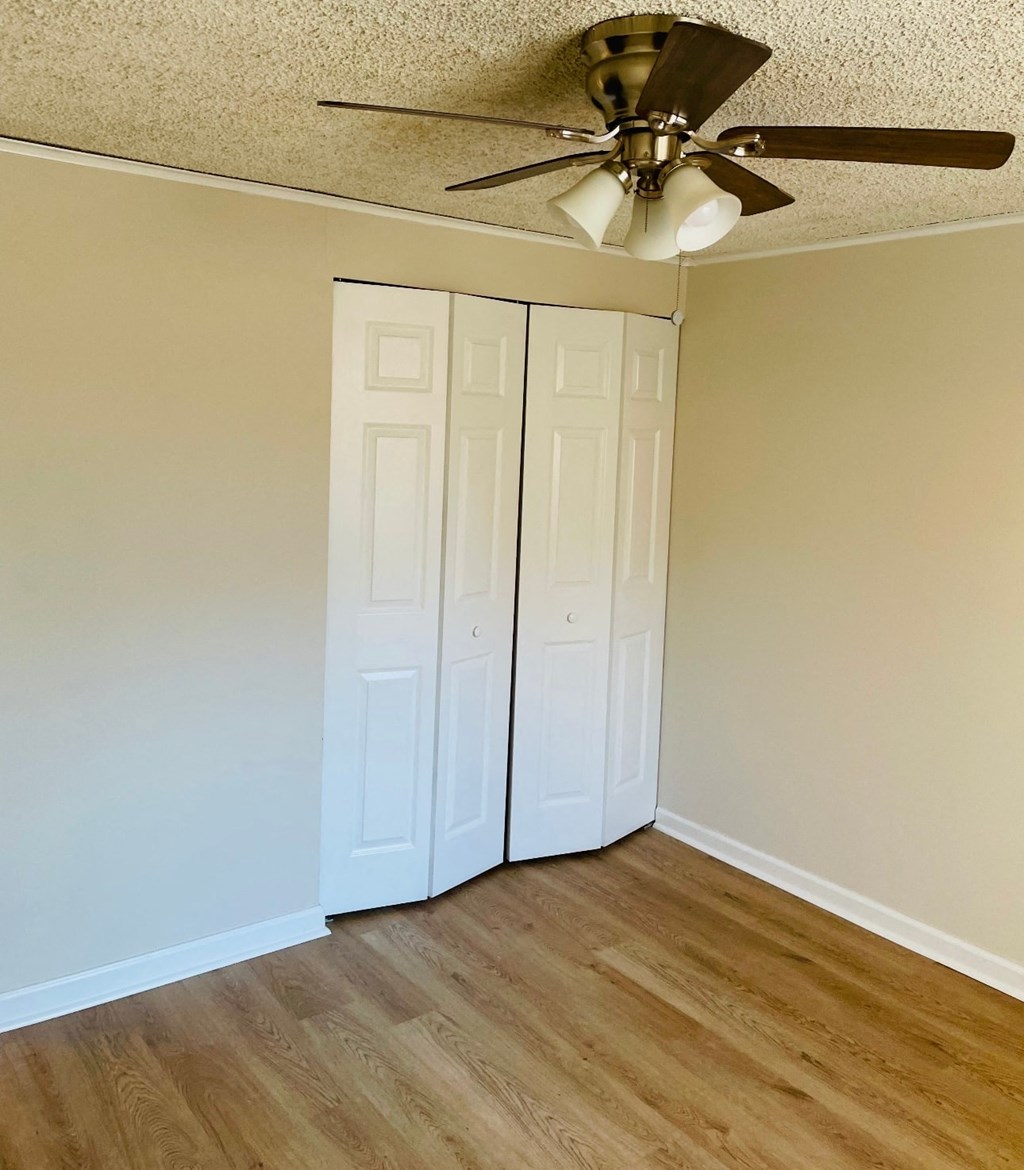 A room with a ceiling fan and two white doors.