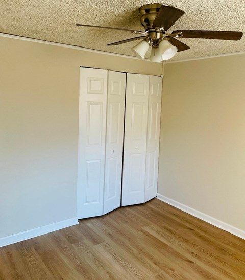 A room with a ceiling fan and two white doors.