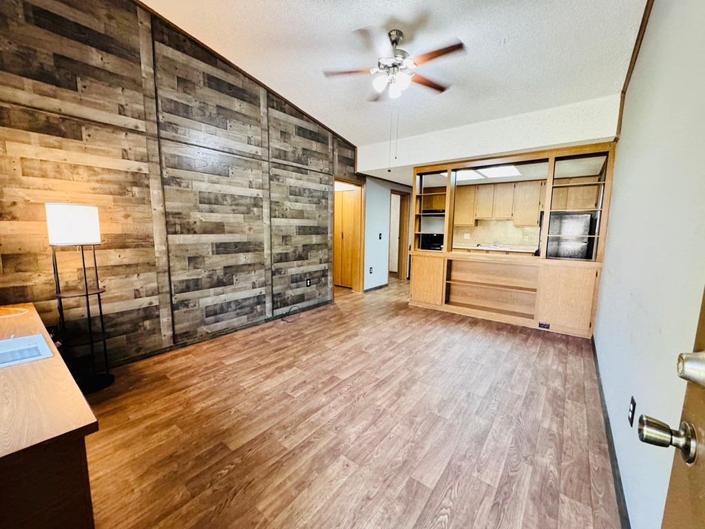A room with wooden floors and a ceiling fan.