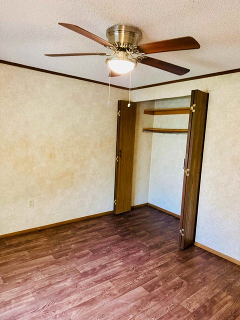 A room with a ceiling fan and a door.