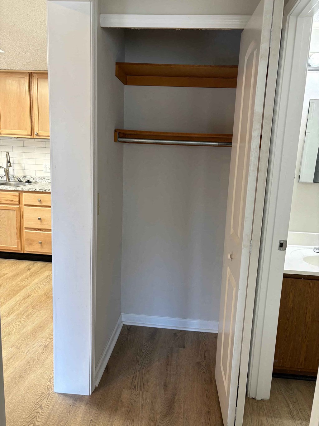 A white door is open to a kitchen.