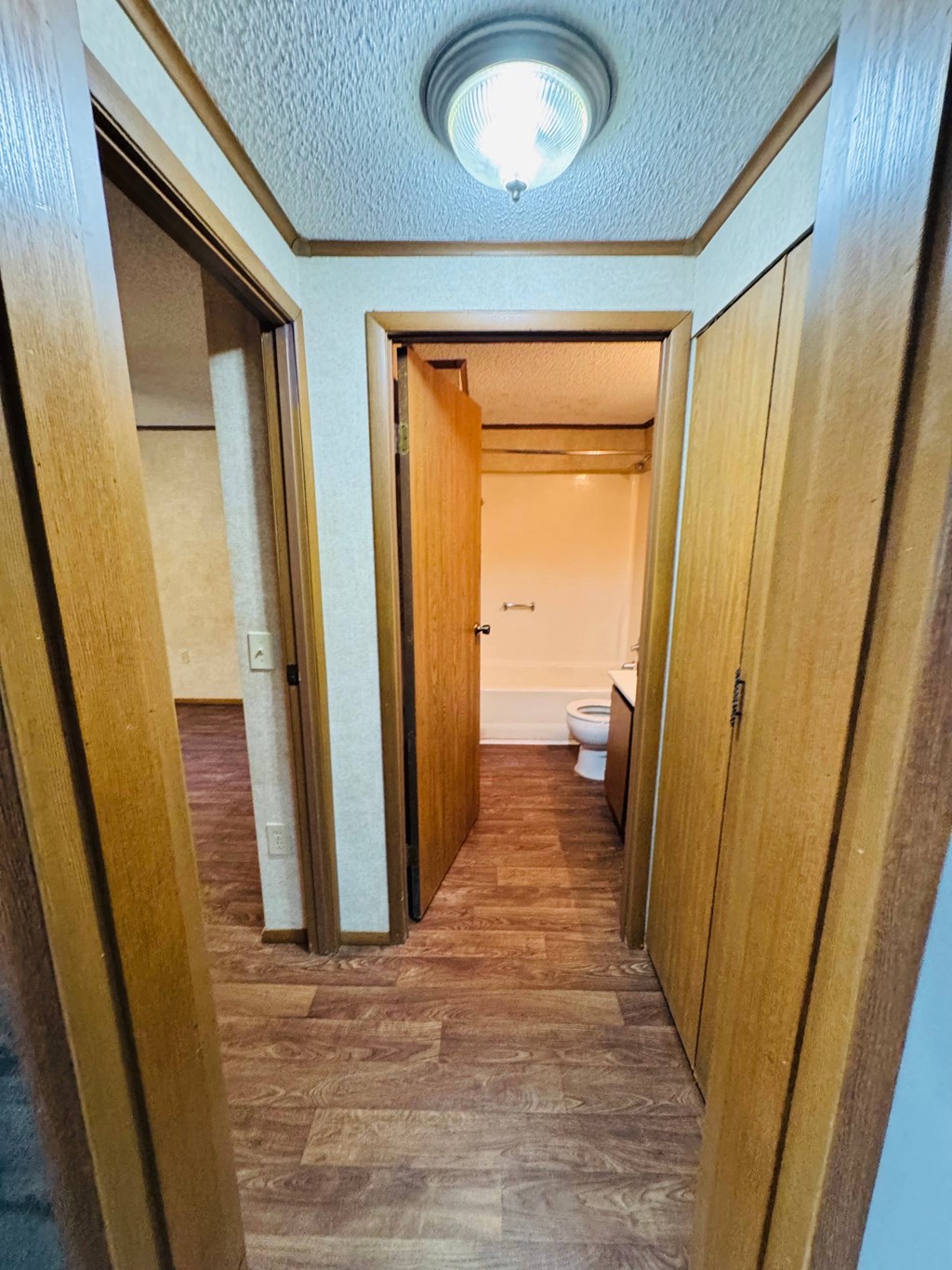 A hallway with wooden doors and a light on the ceiling.