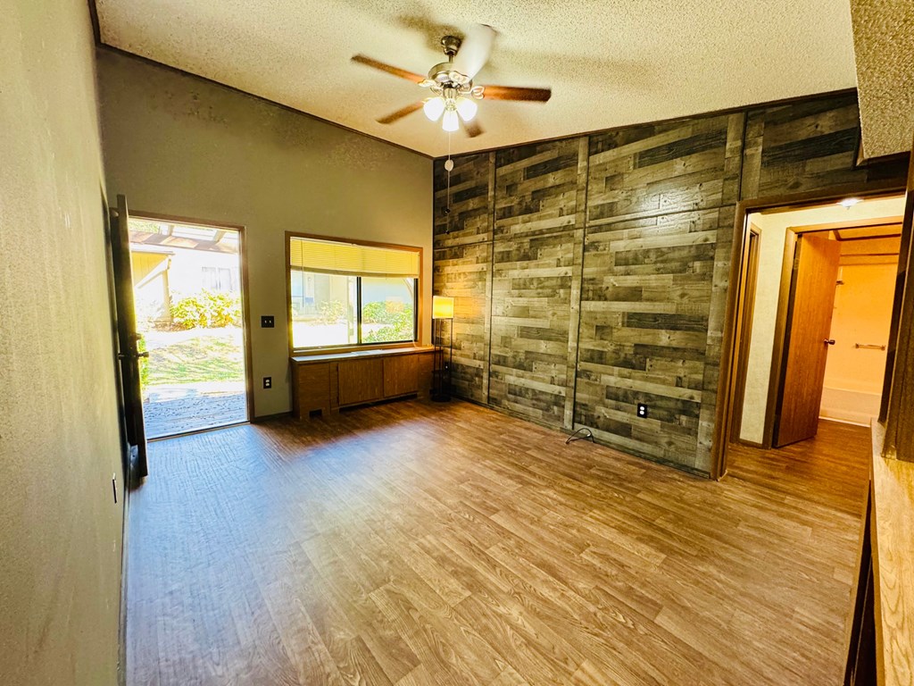 A room with wooden floors and a ceiling fan.