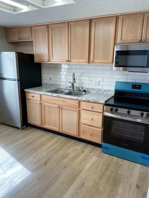 A kitchen with wooden cabinets and a blue oven.