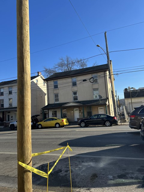 A yellow caution tape is strung between two wooden posts.