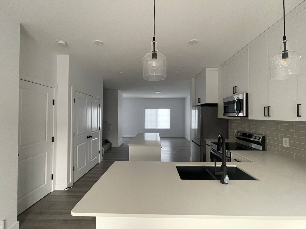 a large white kitchen with white counter tops and a black