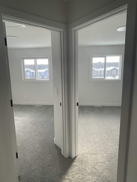 a bedroom with a view of the living room and bedroom door open