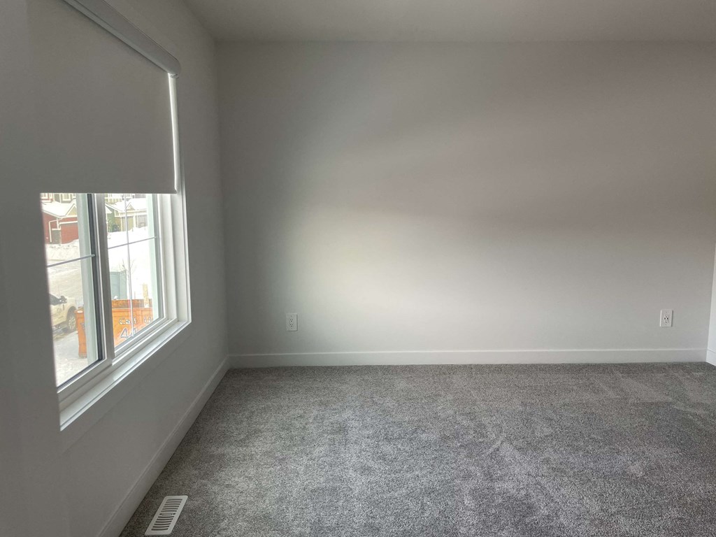 a empty room with a window and carpeting