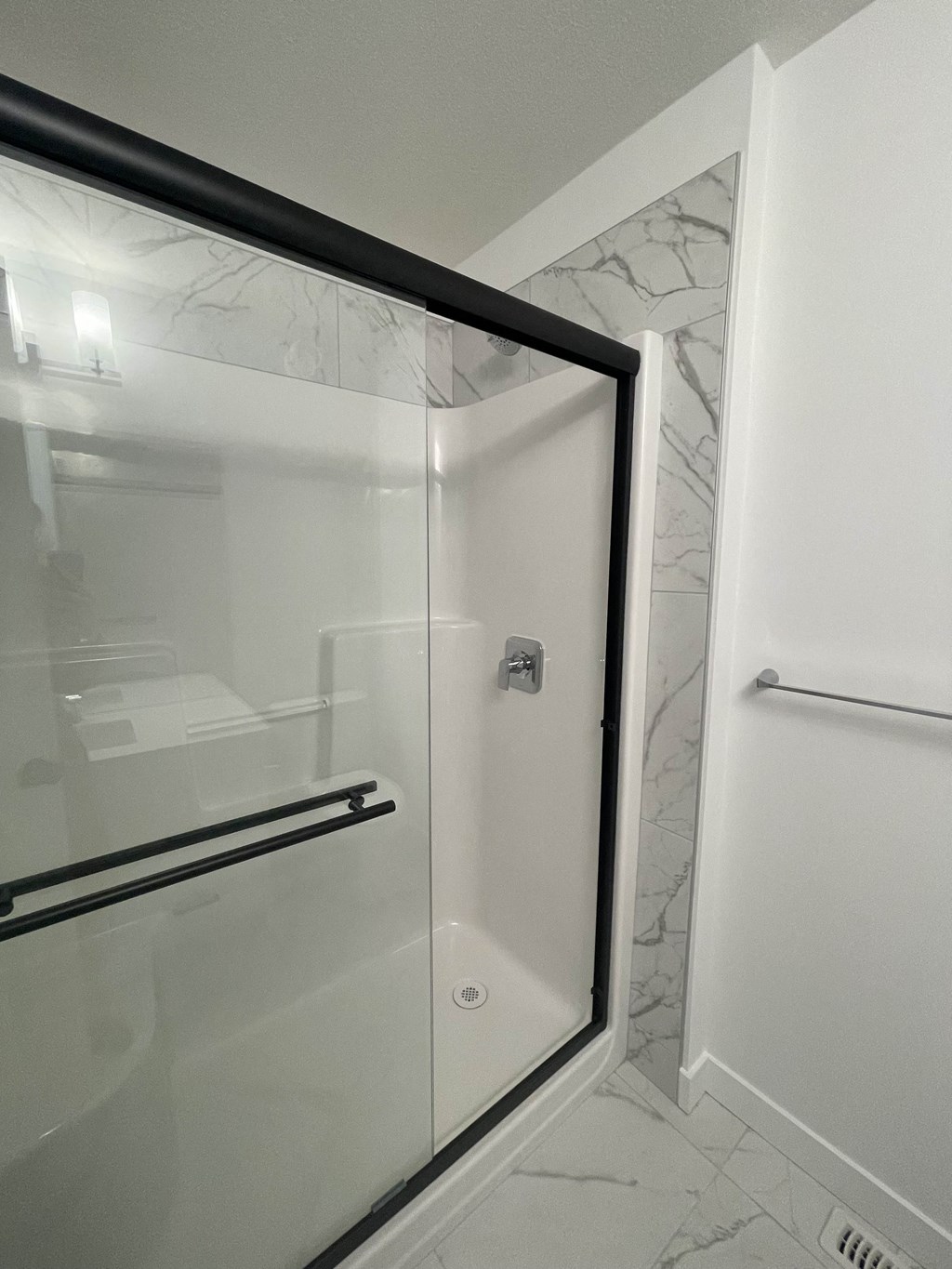 a shower in a bathroom with a glass door
