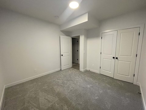 a bedroom with a carpeted floor and white doors